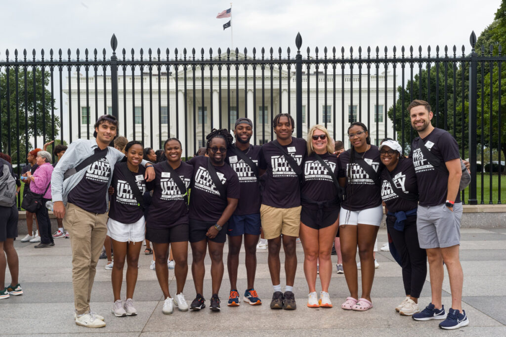 A tour group poses in front of the White House